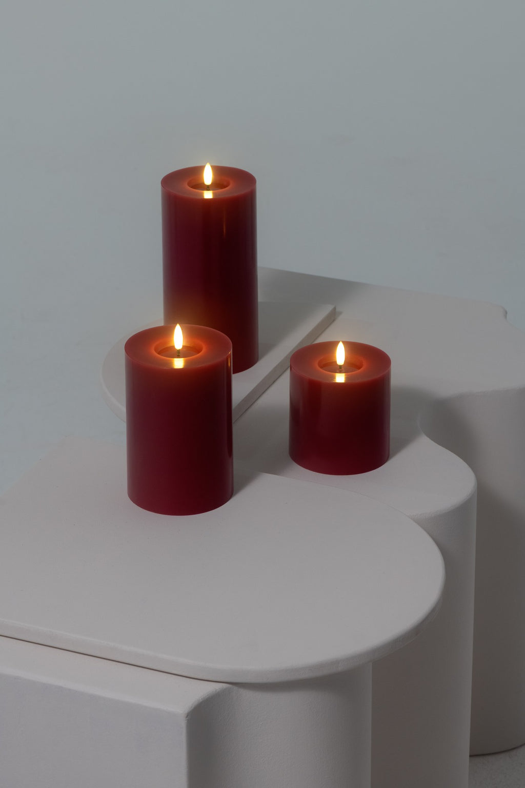 Bougie pilier LED effet cire fondue rouge canneberge, plusieurs tailles réunies sur une table, vue 2