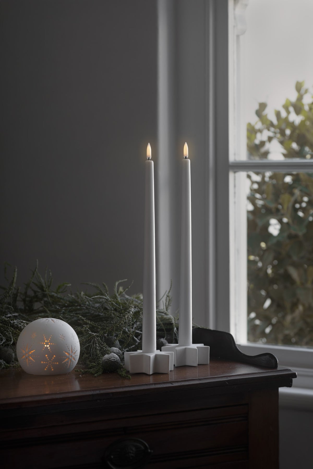 Photophore dôme en céramique blanche ajourée, avec une bougie chauffe-plat LED allumée