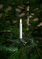 Mini bougies LED fixées par des clips métal sur un sapin de Noël